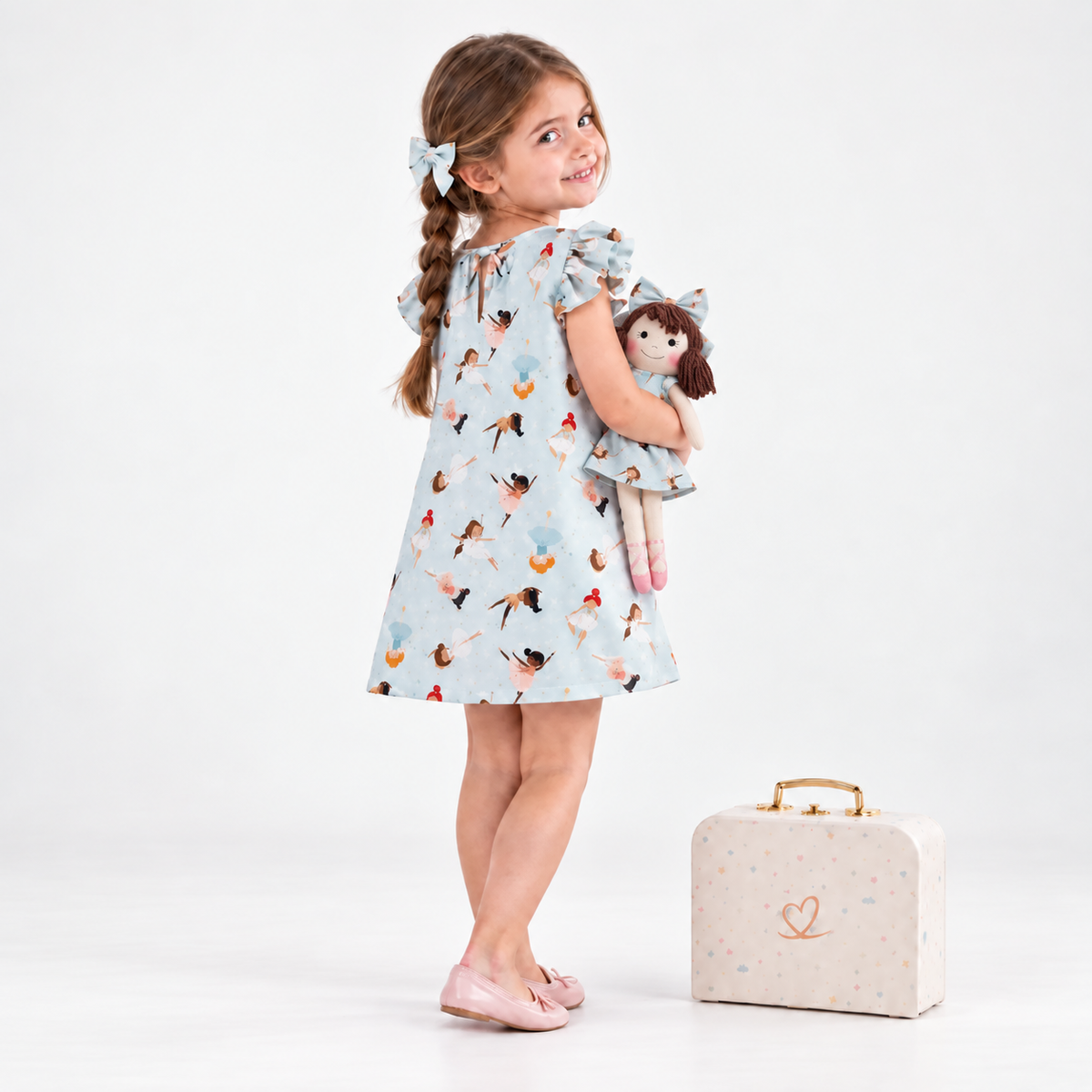 Girl in Ballerina dress holding matching Alice doll, with Petit Case