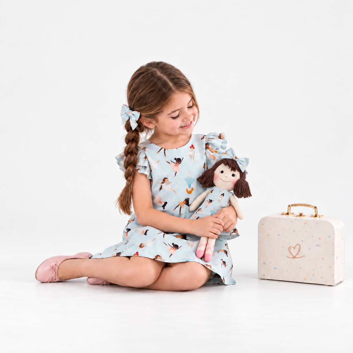 Girl in Ballerina dress holding matching Alice doll, with Petit Case