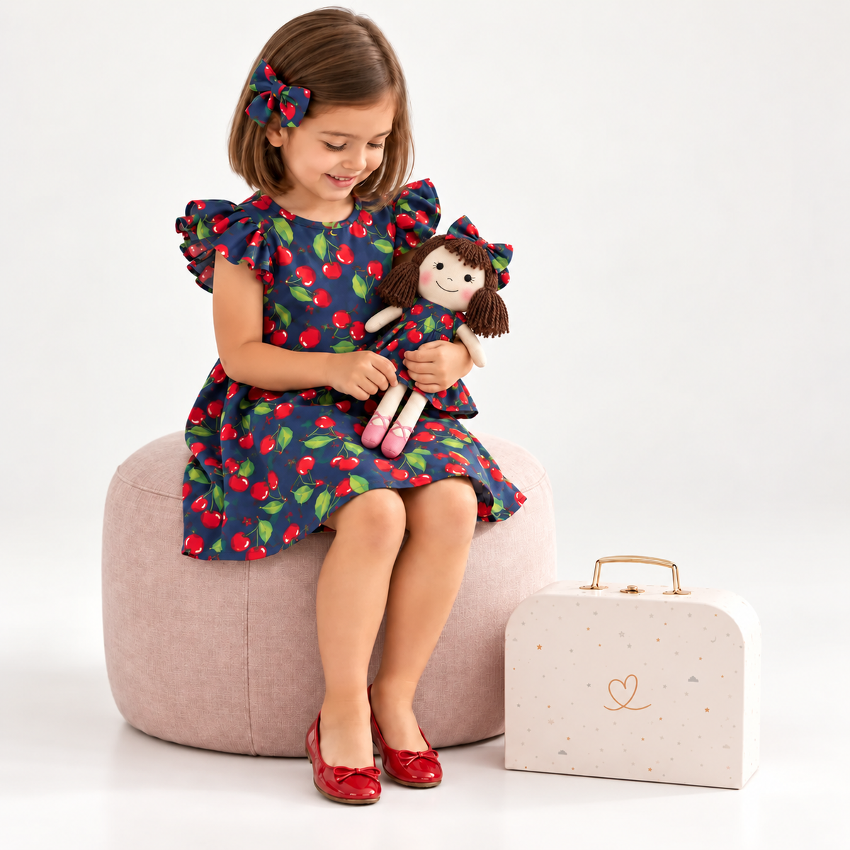 Girl in Cherry dress holding matching Alice doll, with Petit Case