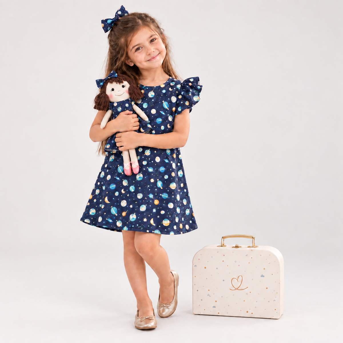 Girl in Space dress holding matching Alice doll, with Petit Case