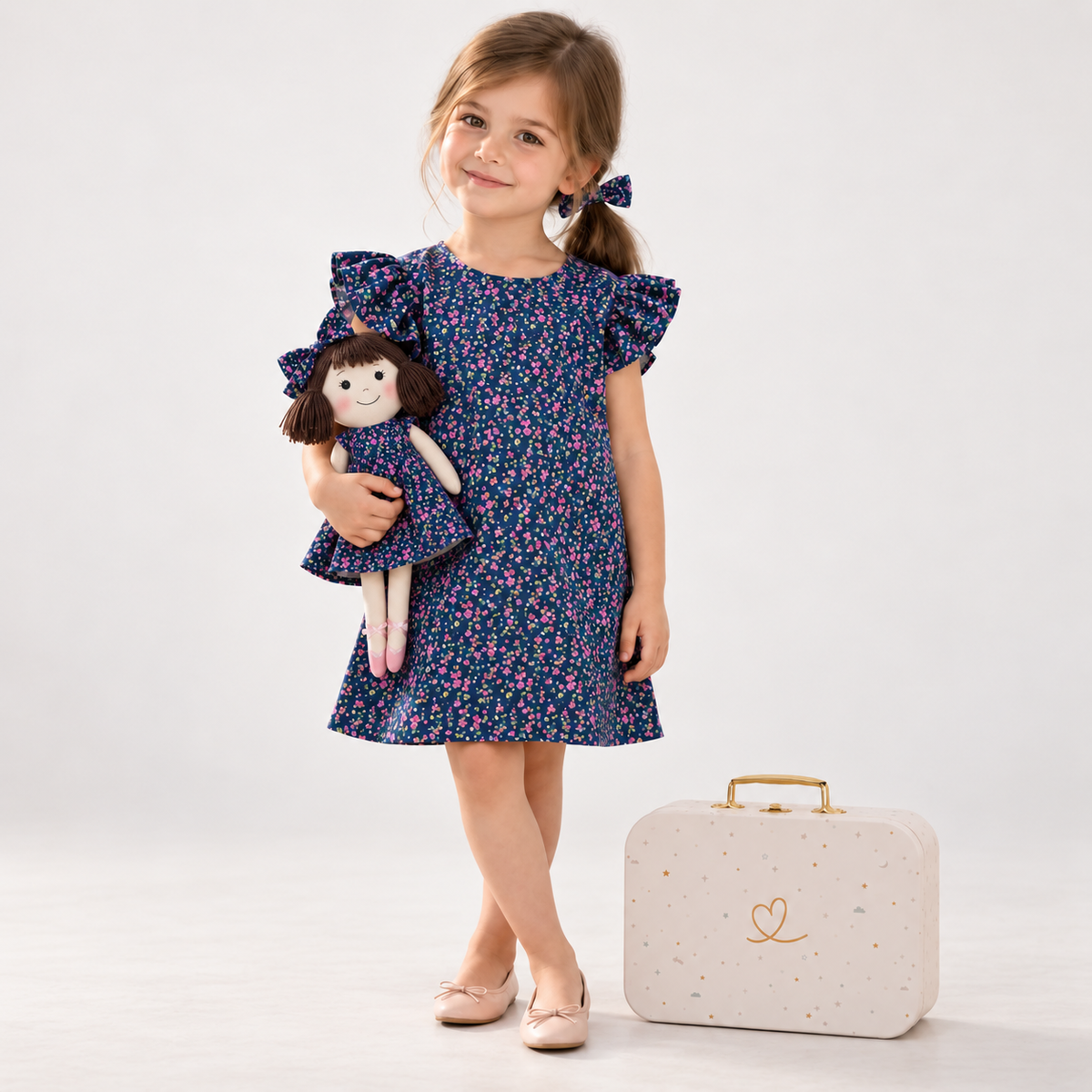 Girl in Blossom dress holding matching Alice doll, with Petit Case