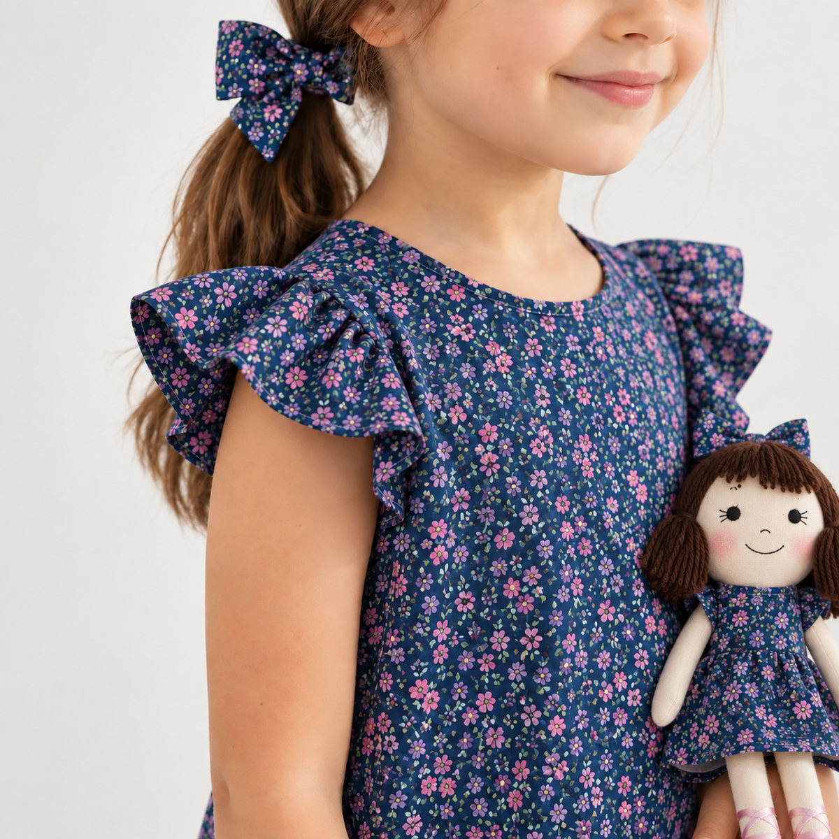 Girl in Blossom dress holding matching Alice doll, with Petit Case
