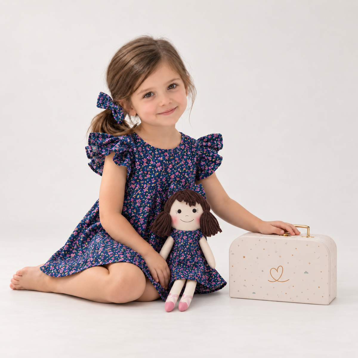 Girl in Blossom dress holding matching Alice doll, with Petit Case