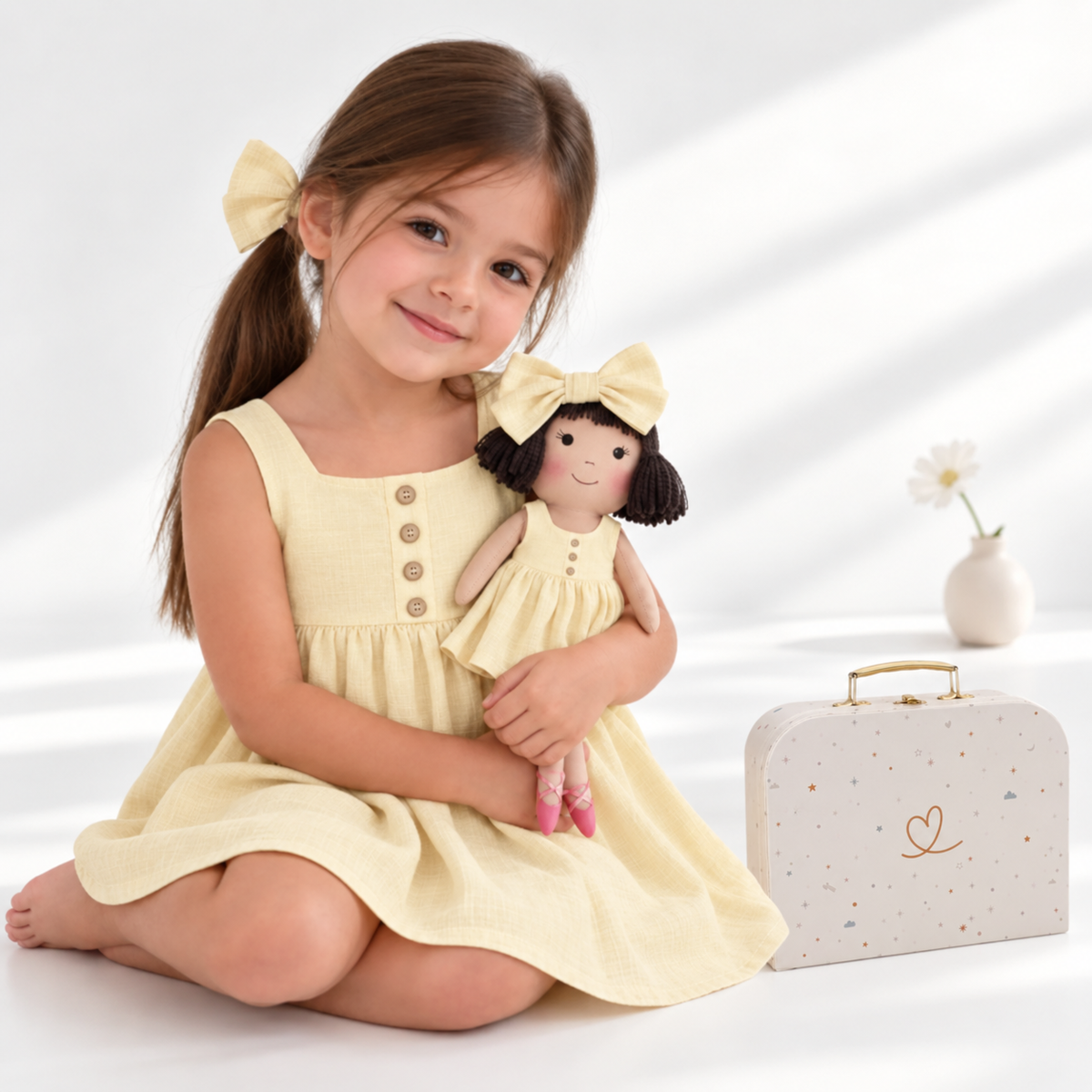Girl in Classic Yellow dress holding matching Alice doll, with Petit Case