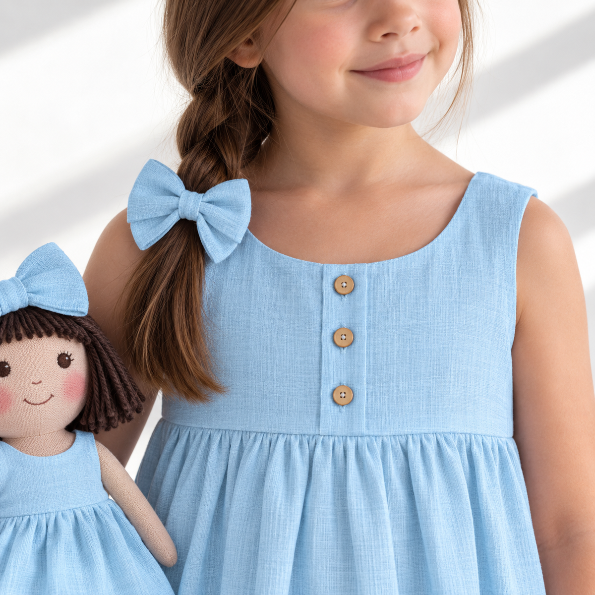 Girl in Classic Blue dress holding matching Alice doll, with Petit Case