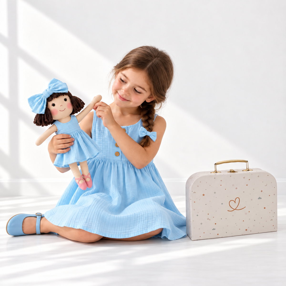 Girl in Classic Blue dress holding matching Alice doll, with Petit Case