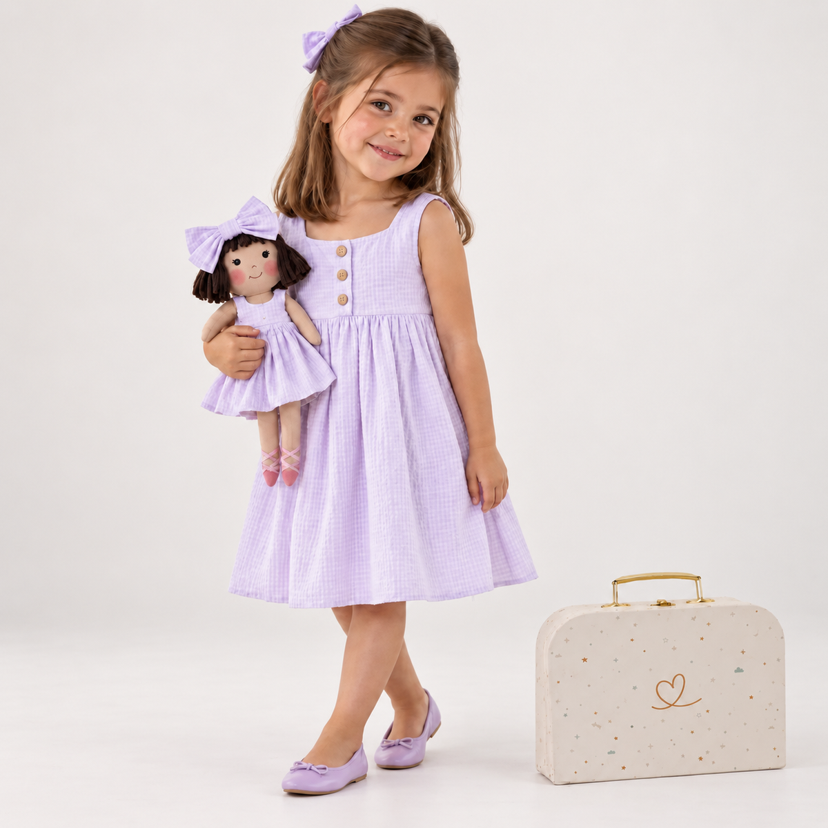 Girl in Classic Lavender dress holding matching Alice doll, with Petit Case