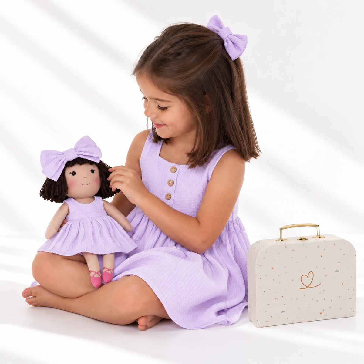 Girl in Classic Lavender dress holding matching Alice doll, with Petit Case