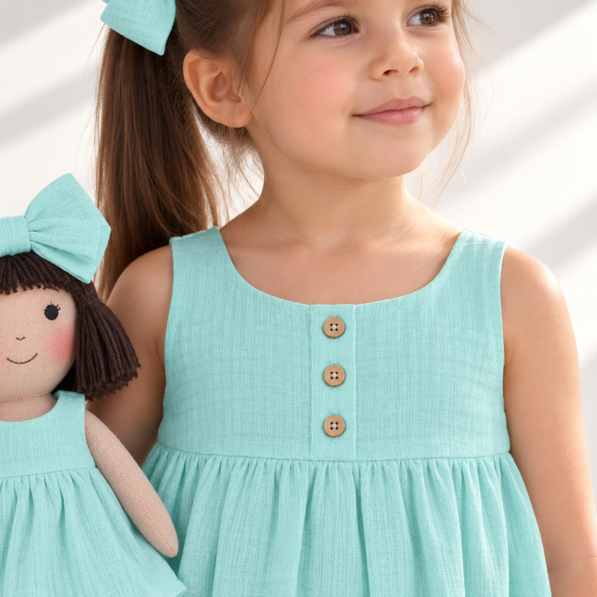 Girl in Classic Green dress holding matching Alice doll, with Petit Case