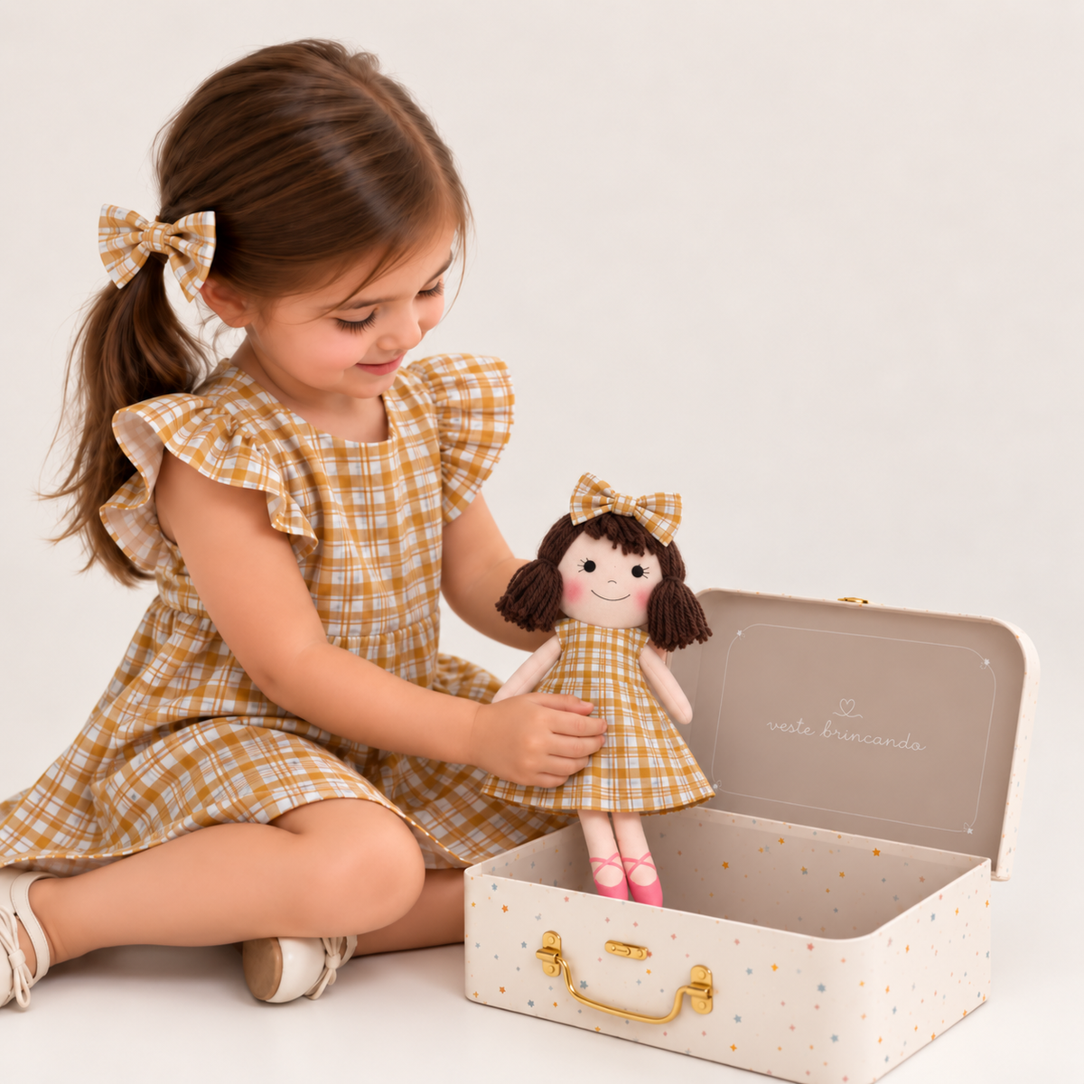 Girl in Gingham dress holding matching Alice doll, with Petit Case