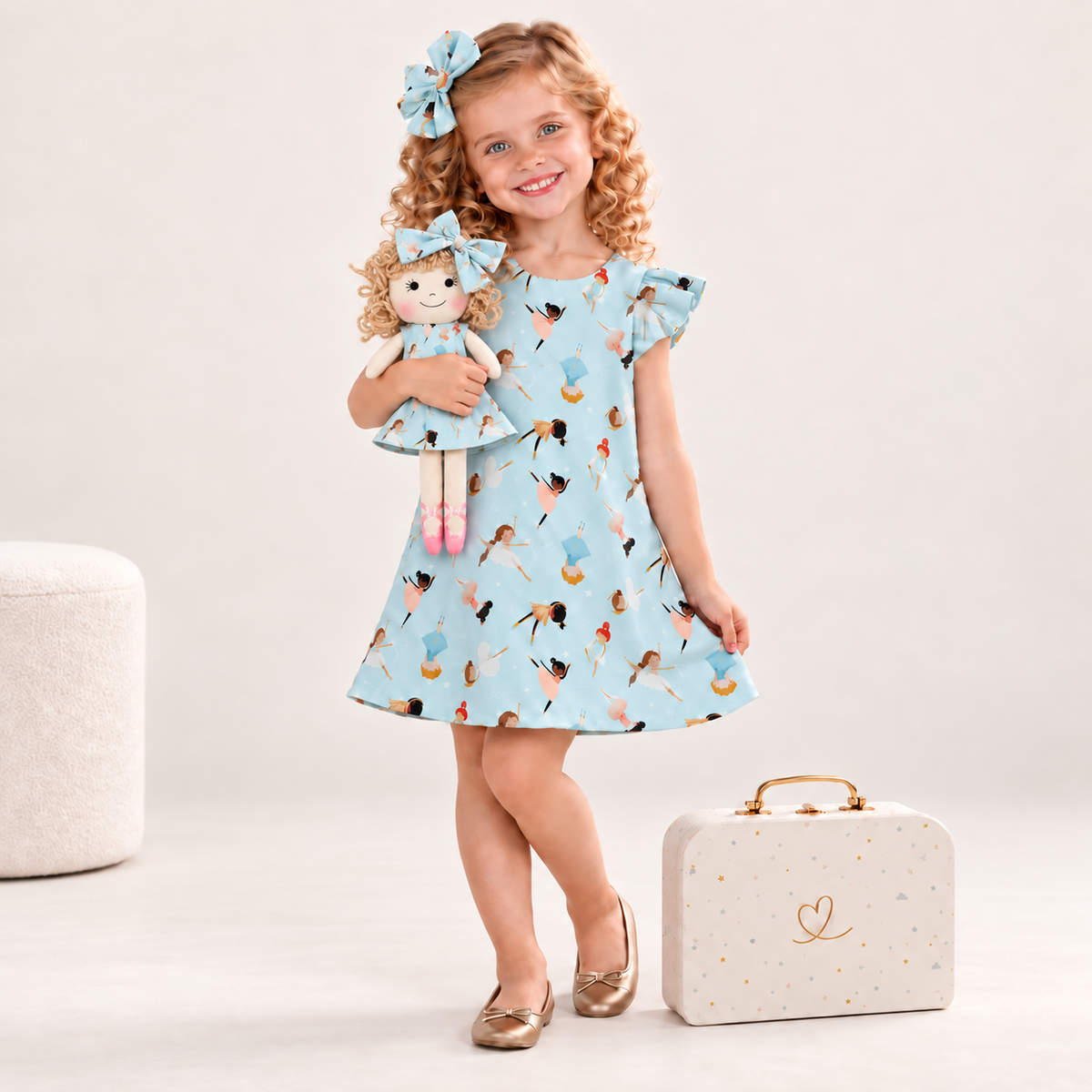 Girl in Ballerina dress holding matching Annie doll, with Petit Case