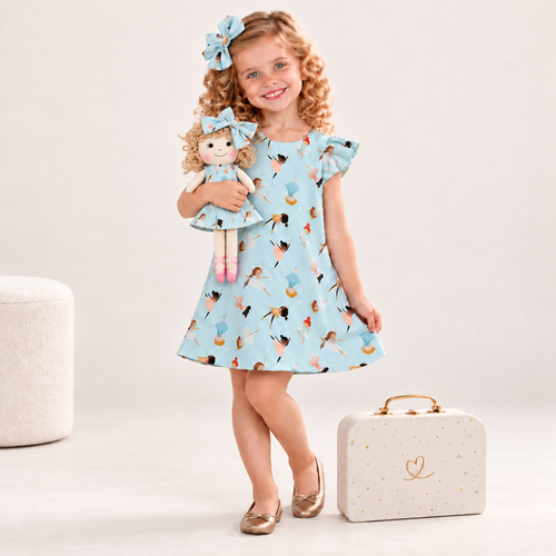 Girl in Ballerina dress holding matching Annie doll, with Petit Case