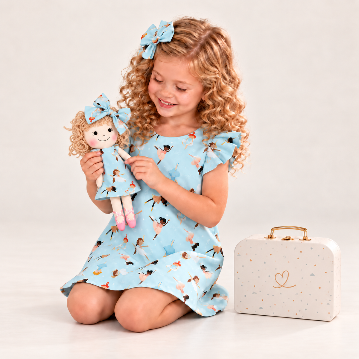 Girl in Ballerina dress holding matching Annie doll, with Petit Case
