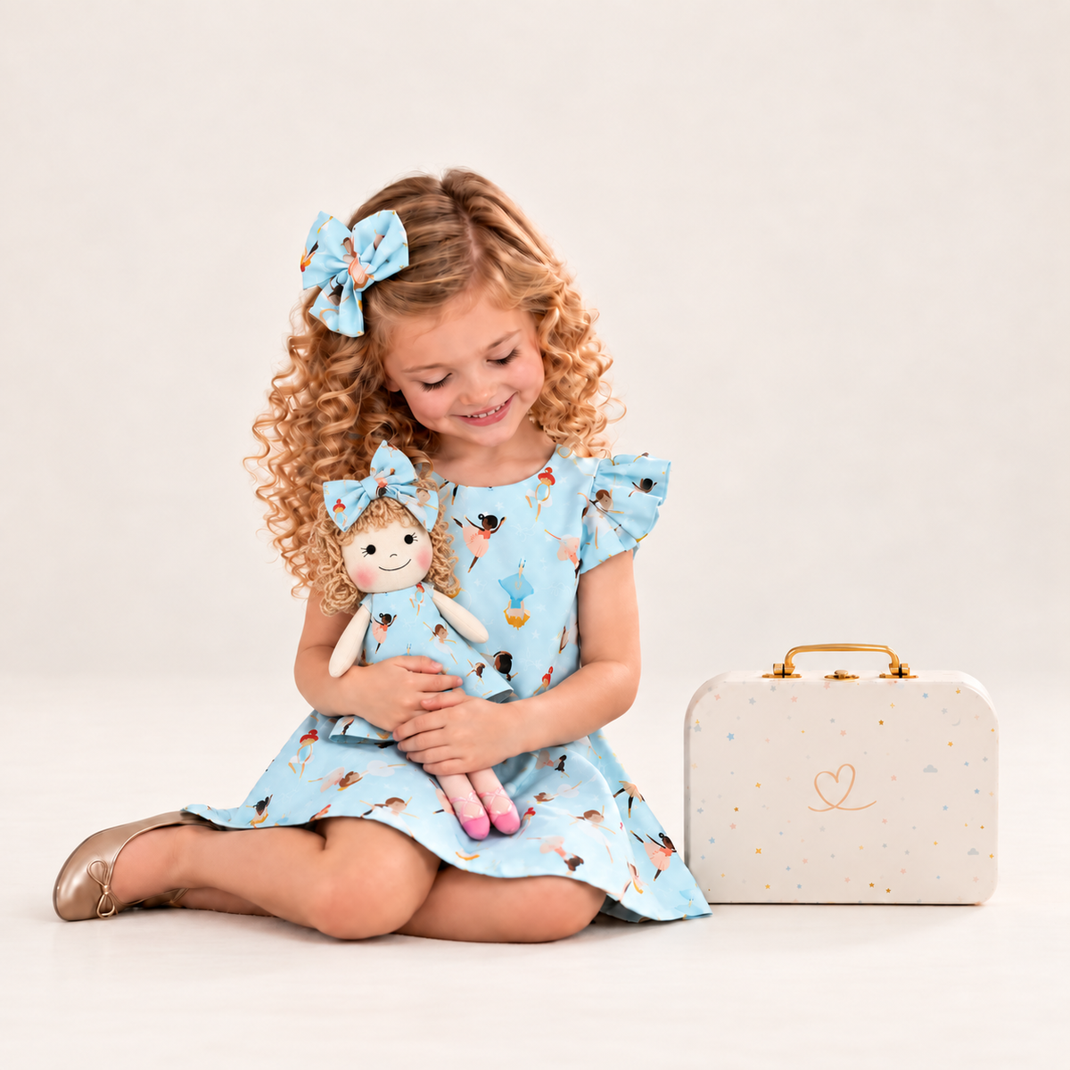 Girl in Ballerina dress holding matching Annie doll, with Petit Case