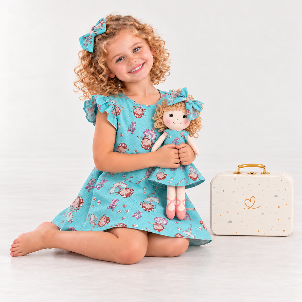 Girl in Ballet dress holding matching Annie doll, with Petit Case