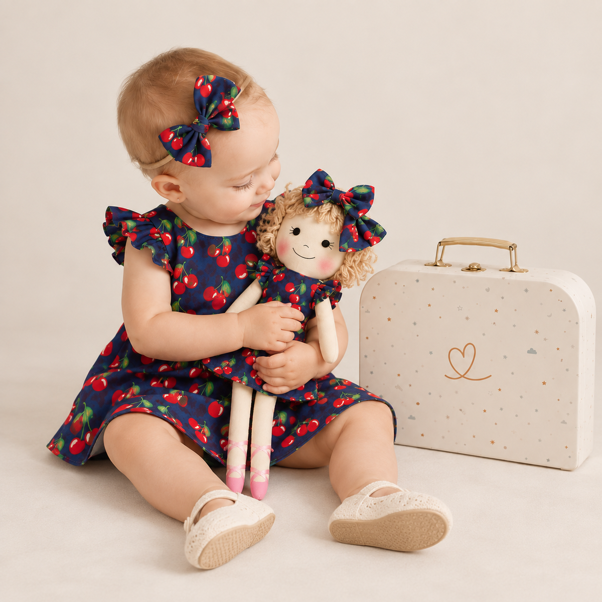 Girl in Cherry dress holding matching Annie doll, with Petit Case