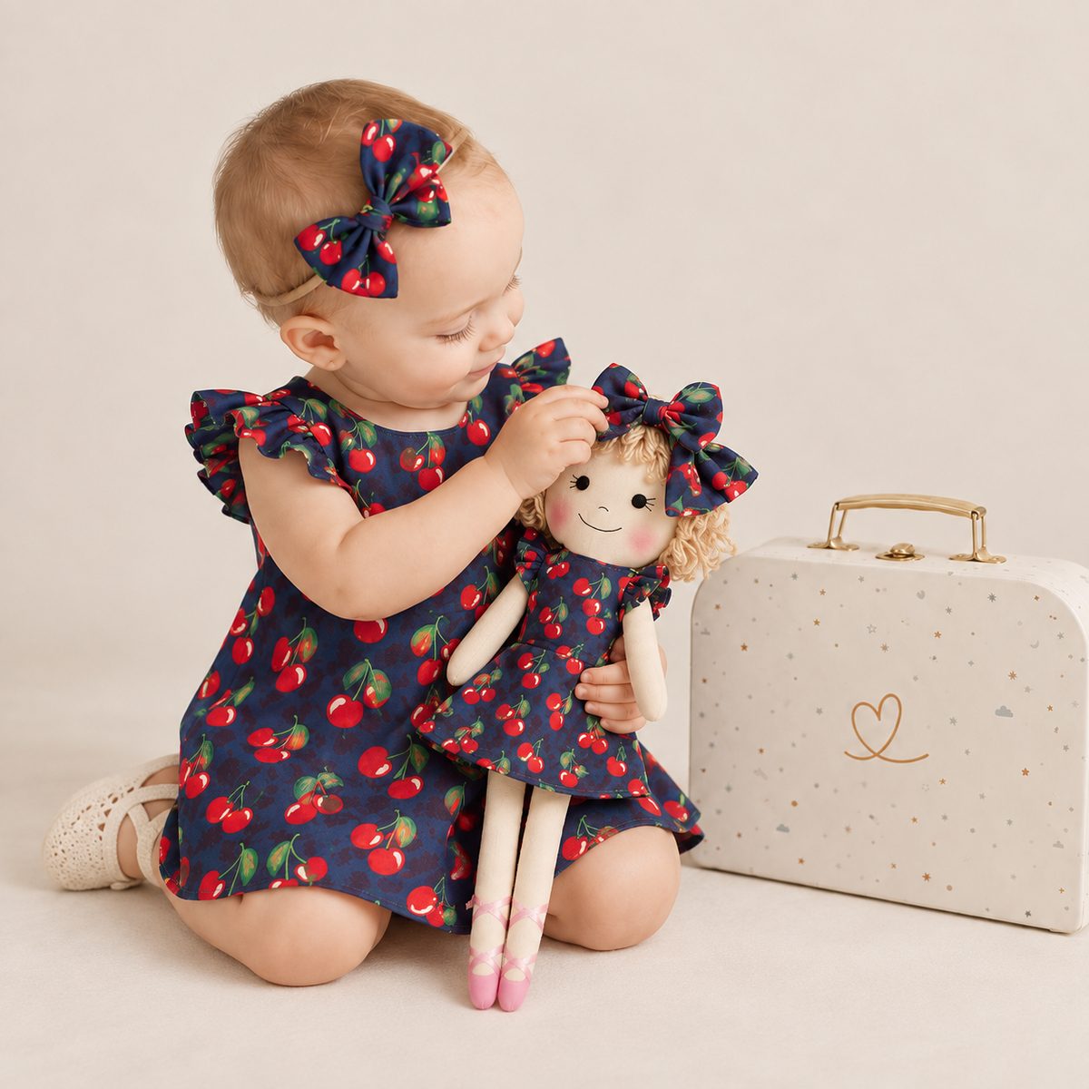 Girl in Cherry dress holding matching Annie doll, with Petit Case
