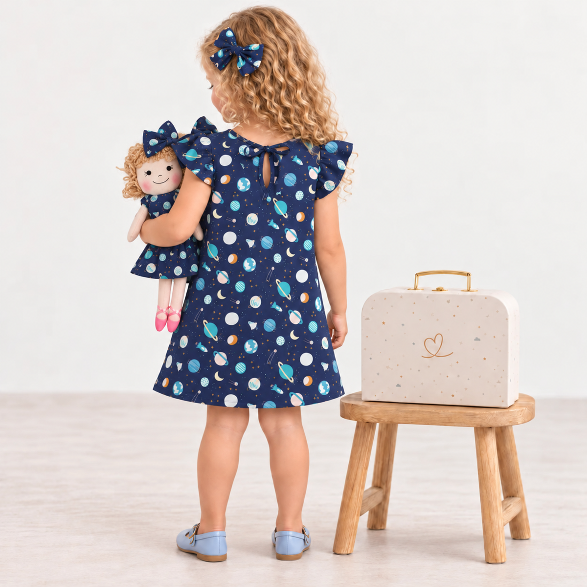 Girl in Space dress holding matching Annie doll, with Petit Case