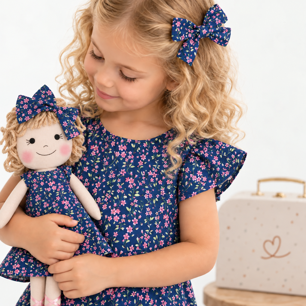 Girl in Blossom dress holding matching Annie doll, with Petit Case