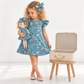 Girl in Under the Sea dress holding matching Annie doll, with Petit Case