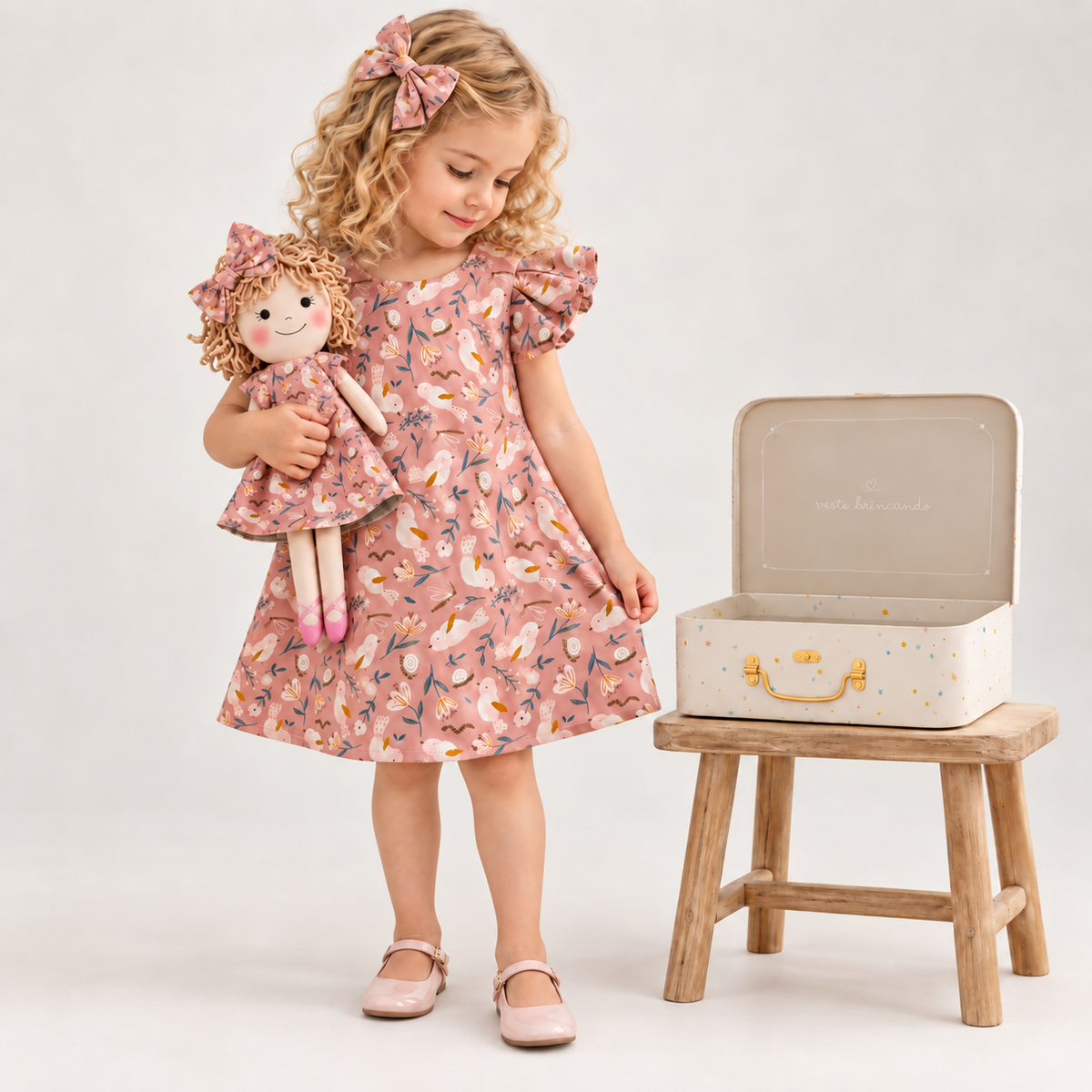 Girl in Garden dress holding matching Annie doll, with Petit Case