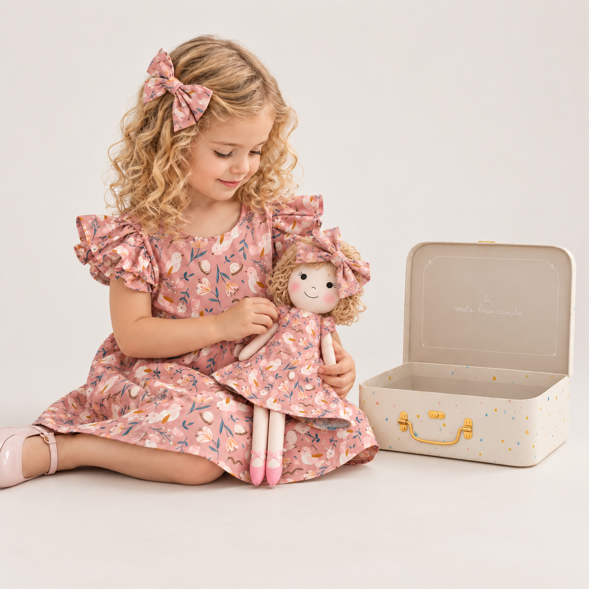 Girl in Garden dress holding matching Annie doll, with Petit Case