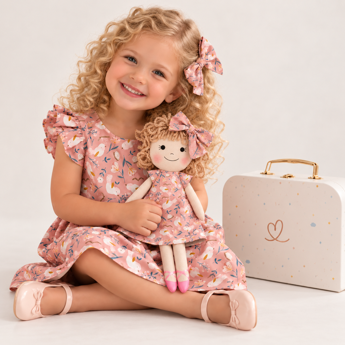 Girl in Garden dress holding matching Annie doll, with Petit Case