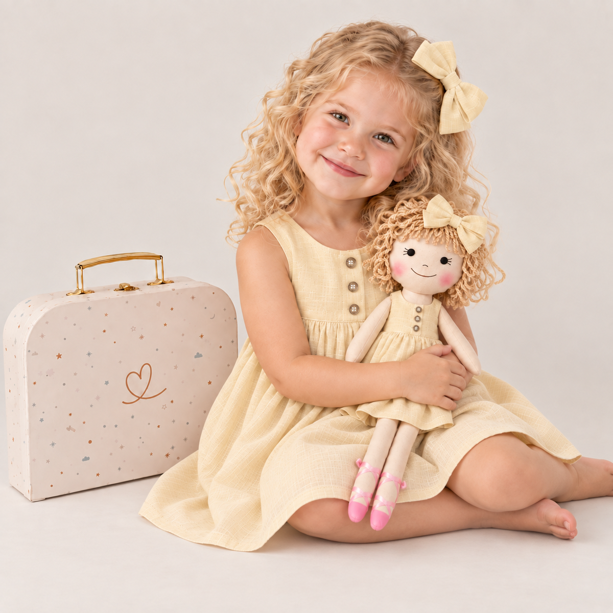 Girl in Classic Yellow dress holding matching Annie doll, with Petit Case