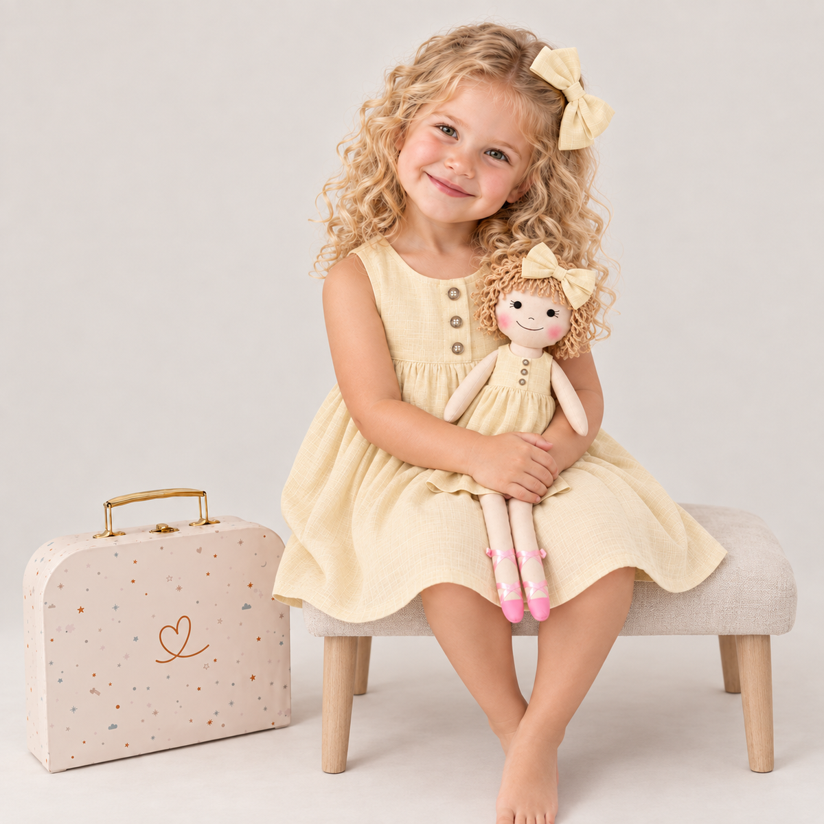 Girl in Classic Yellow dress holding matching Annie doll, with Petit Case