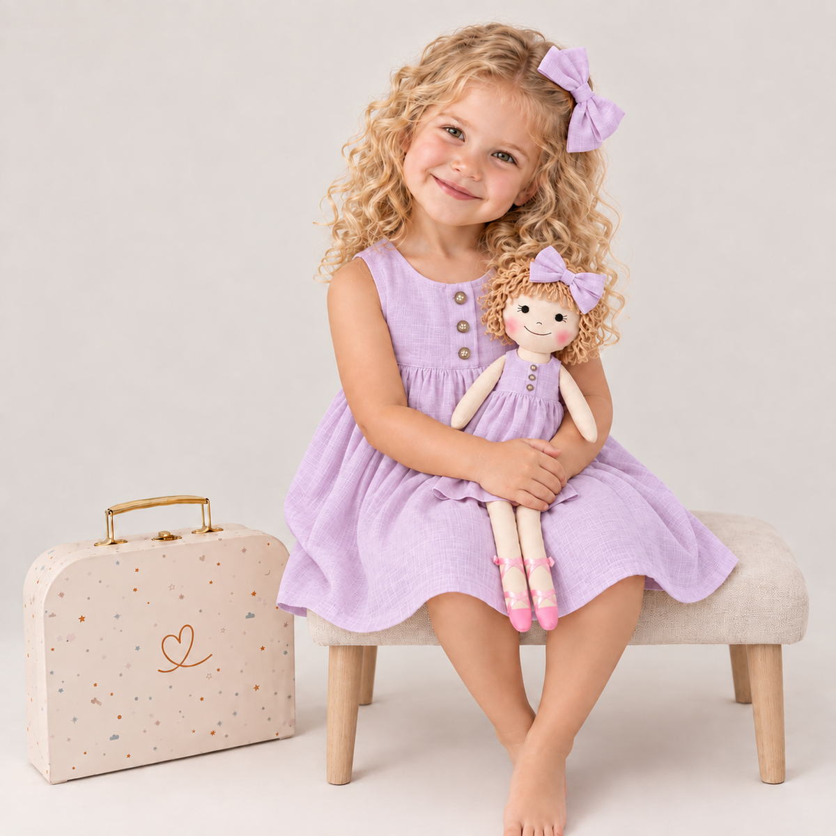Girl in Classic Lavender dress holding matching Annie doll, with Petit Case