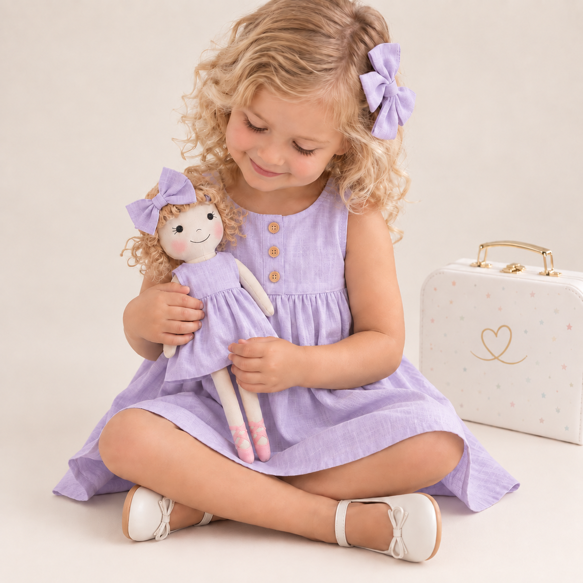 Girl in Classic Lavender dress holding matching Annie doll, with Petit Case