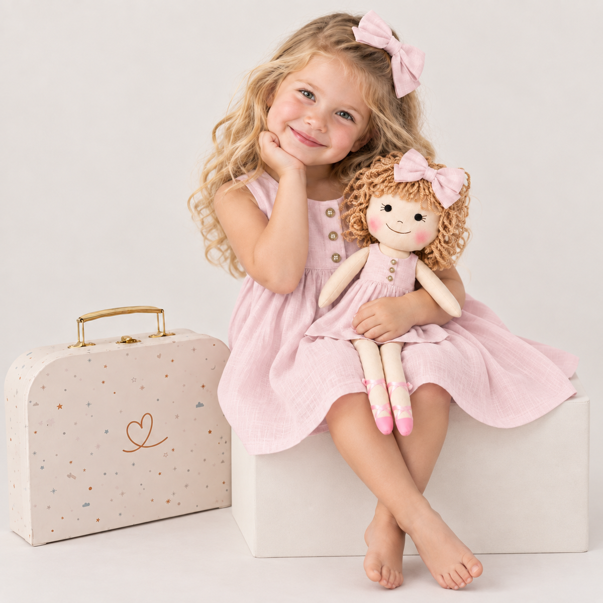 Girl in Classic Pink dress holding matching Annie doll, with Petit Case