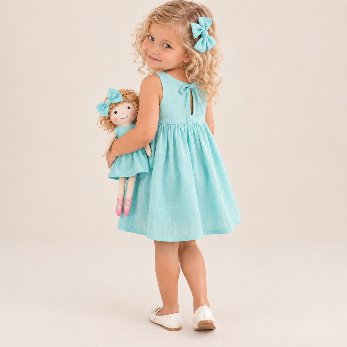 Girl in Classic Green dress holding matching Annie doll, with Petit Case